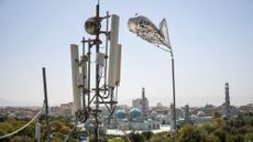 A Taliban flag flutters next to telecom equipment in Mazar-i-Sharif, Afghanistan.