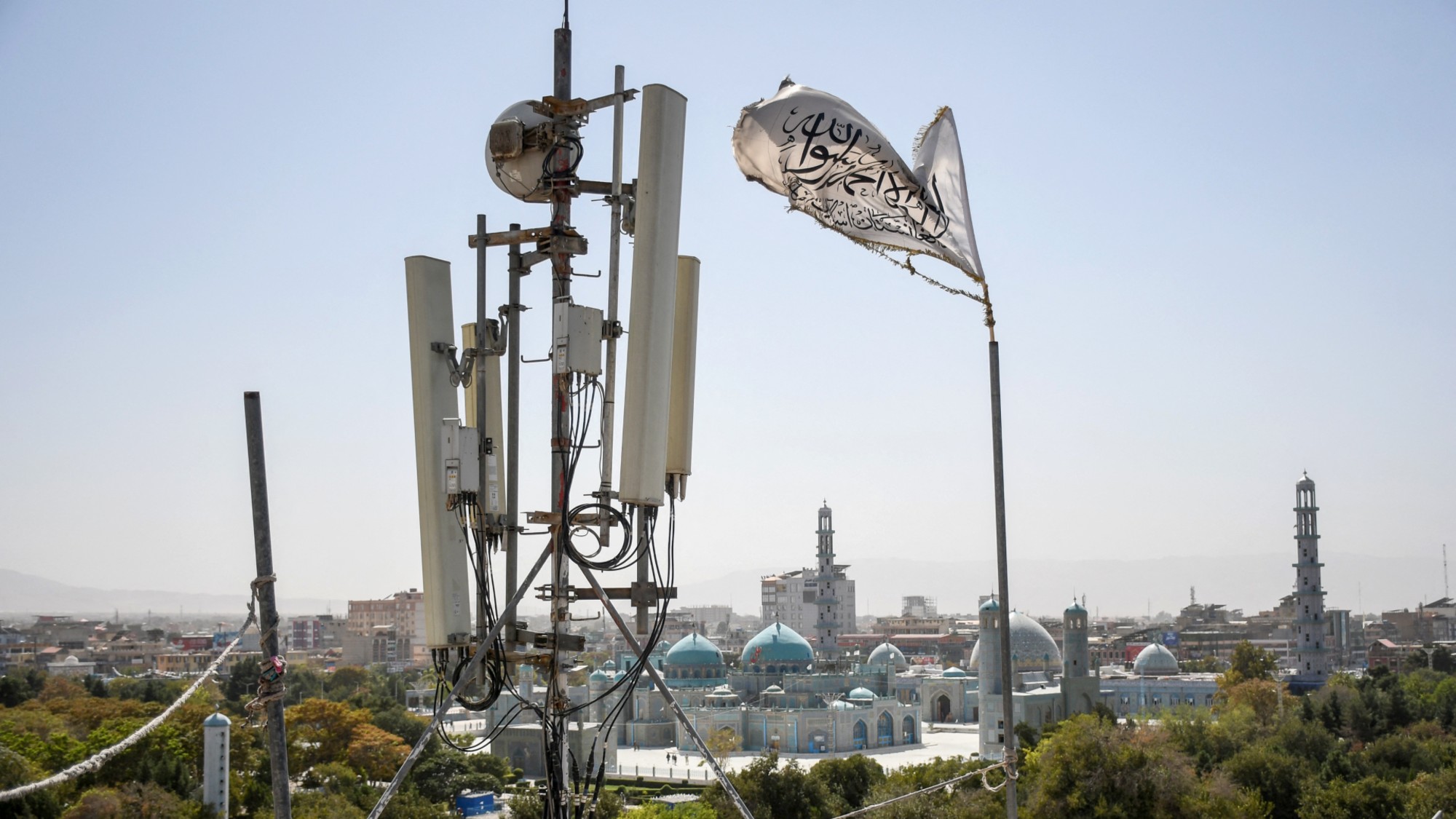 A Taliban flag flutters next to telecom equipment in Mazar-i-Sharif, Afghanistan.