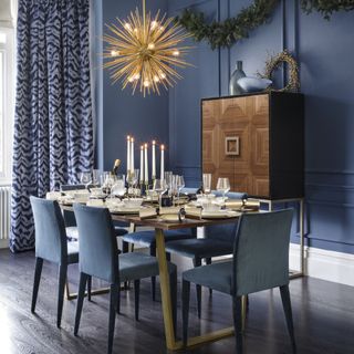 dining room with dark blue walls and gold sputnik light