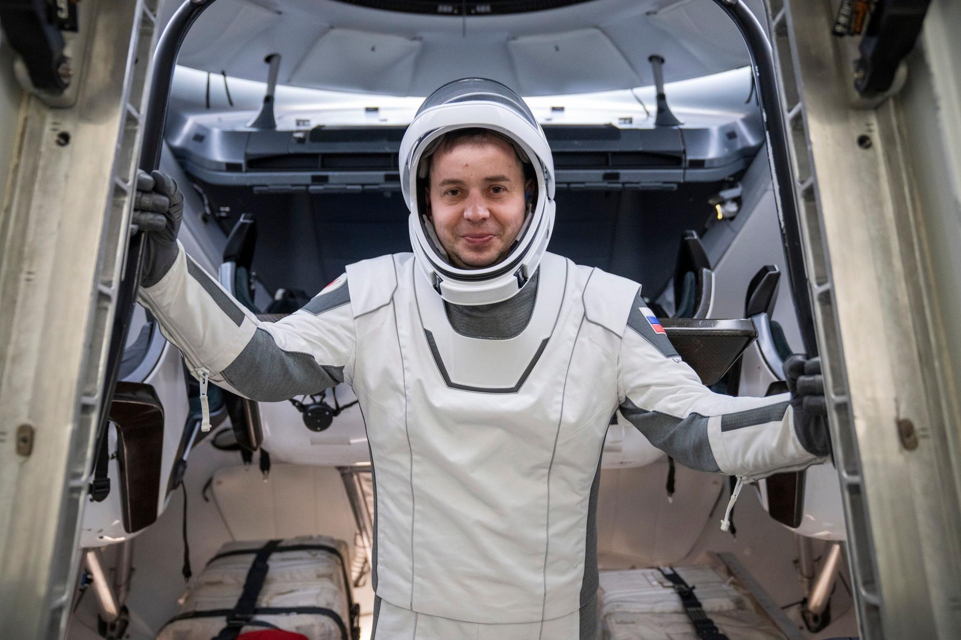 astronaut in a white spacesuit poses for a portrait
