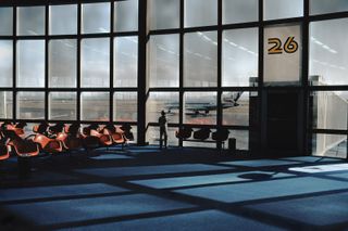 A boy staring through the glass windows at the seating area of gate 26 in Las Vegas International airport in 1982