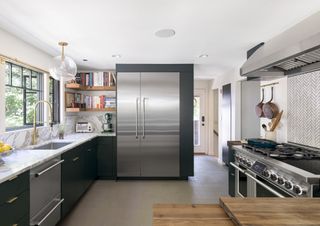 a kitchen with a large fridge and two drawer dishwashers