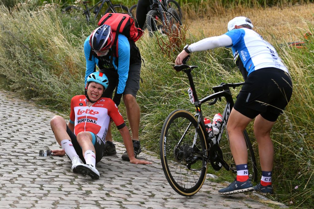 CHAPELLELEZHERLAIMONT BELGIUM JULY 27 Arnaud De Lie of Belgium and Team Lotto Soudal crashes in a cobblestones sector during the 43rd Ethias Tour de Wallonie 2022 Stage 5 a 2148km stage from Le Roeulx to ChapellelezHerlaimont ethiastourdewallonie22 on July 27 2022 in ChapellelezHerlaimont Belgium Photo by Luc ClaessenGetty Images