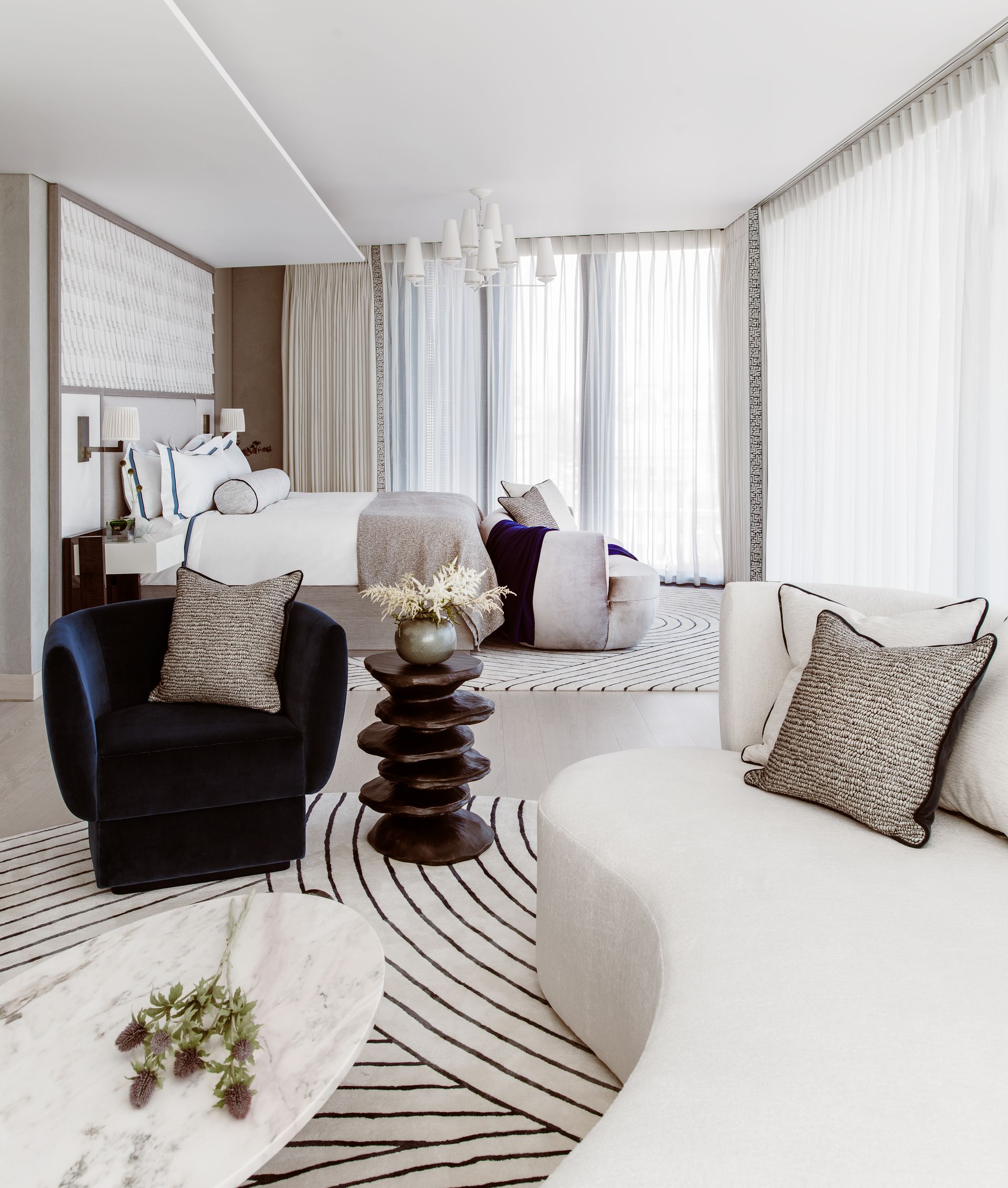 Bedroom with seating area with couch and armchair in neutral and blue