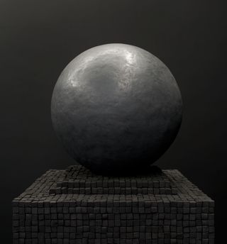 A big grey ball on small grey blocks