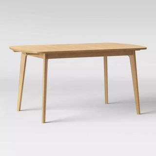 A wooden table with thin legs in a natural wood color