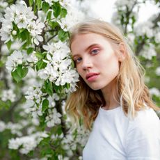 a woman posing next to flowers - vegan make-up