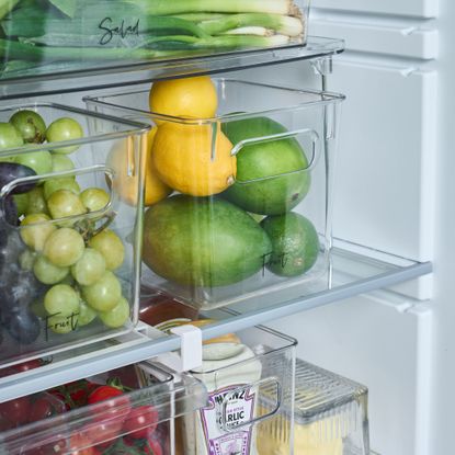 Fruit, veg and condiments in fridge organisers inside of a fridge