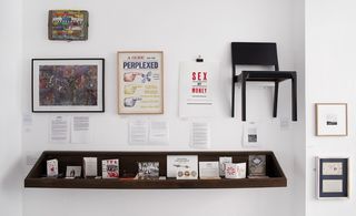 Photographs, letter,chair,posters,press cuttings all in one wall.
