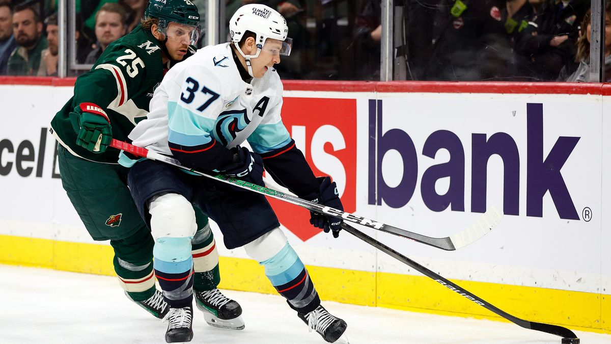 anni Gourde #37 of the Seattle Kraken skates with the puck against Jonas Brodin #25 of the Minnesota Wild in the first period at Xcel Energy Center on April 18, 2024