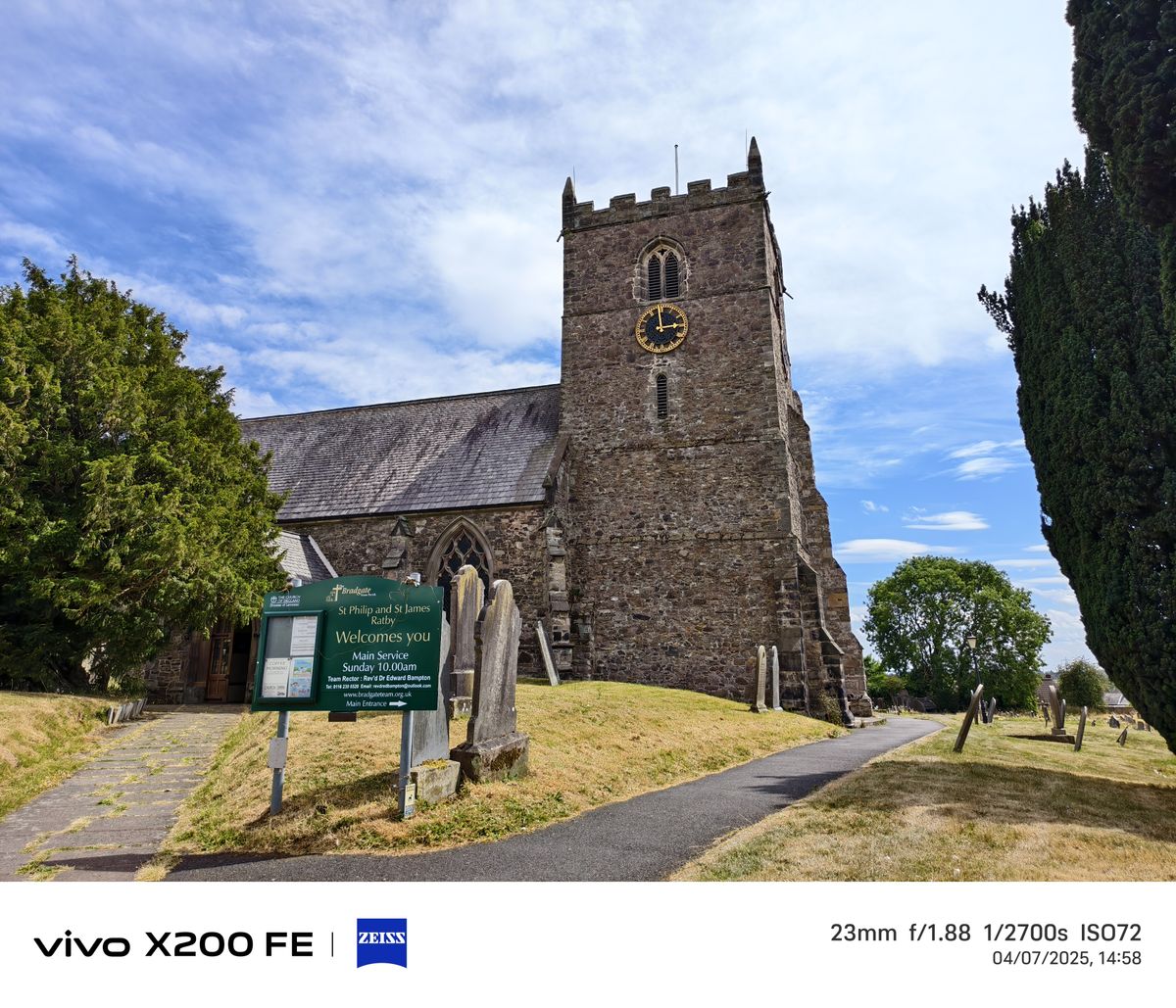 A church in front of a blue sky surrounded by graveyard