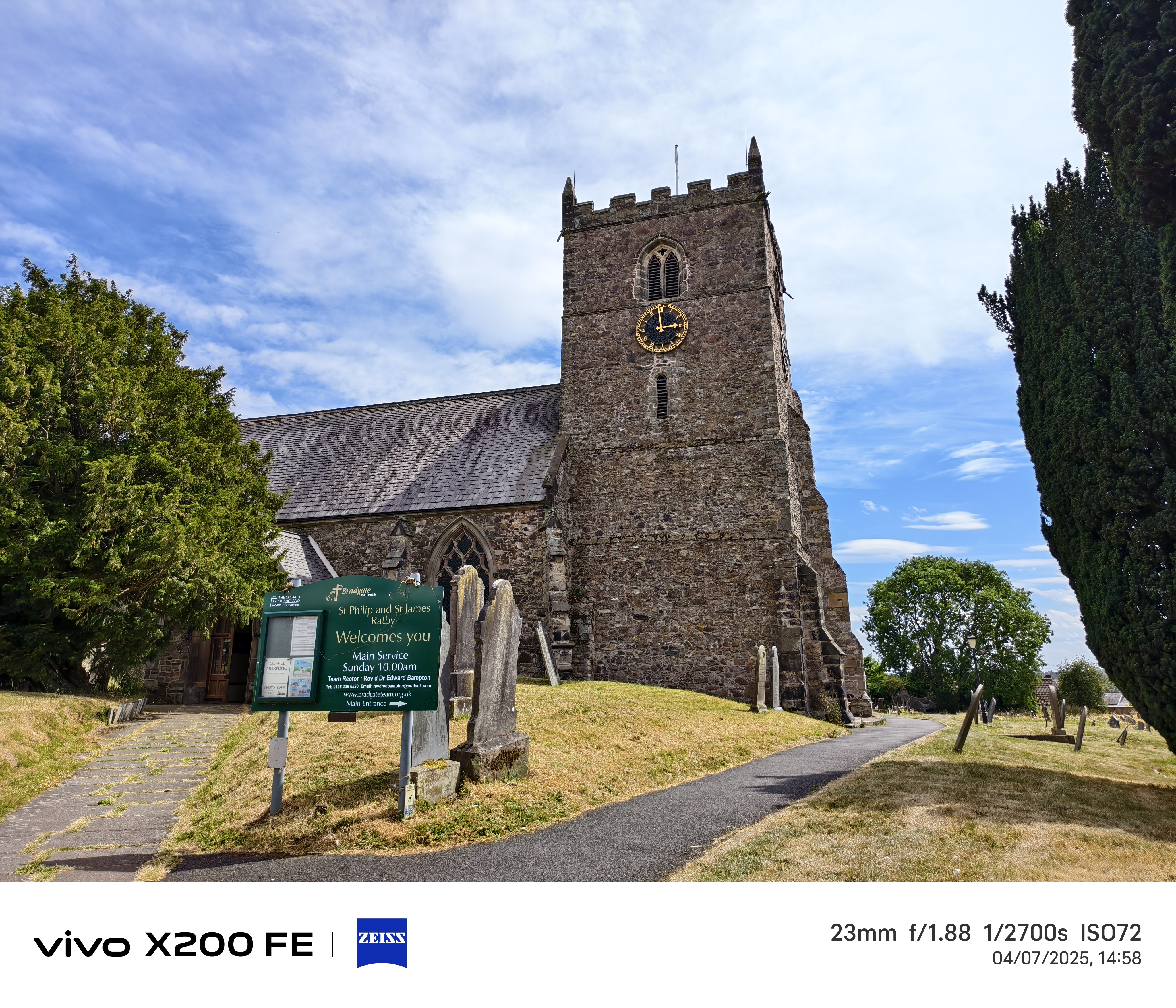 A church in front of a blue sky surrounded by graveyard