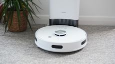 The EZVIZ RE4 Plus robot vacuum in a carpeted living room