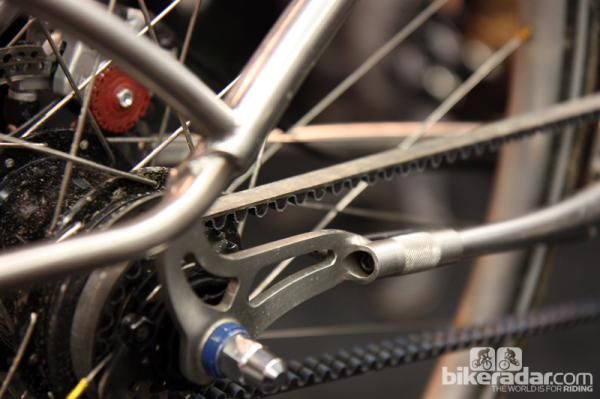 Belt tension on this Naked Bicycles machine is first adjusted by loosening the locking bolt (accessed with an Allen wrench from the back) and then turning the knurled barrel. Simple and elegant.