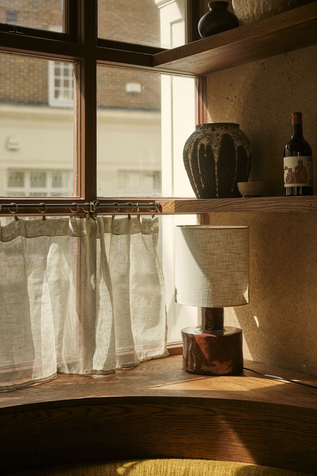 A series of handcrafted accessories, including ceramics and quirky table lamps, sit in a beautifully decorated restaurant filled with natural light.