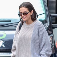 Selena Gomez wearing a sweater, butter yellow pants, and suede clogs in London