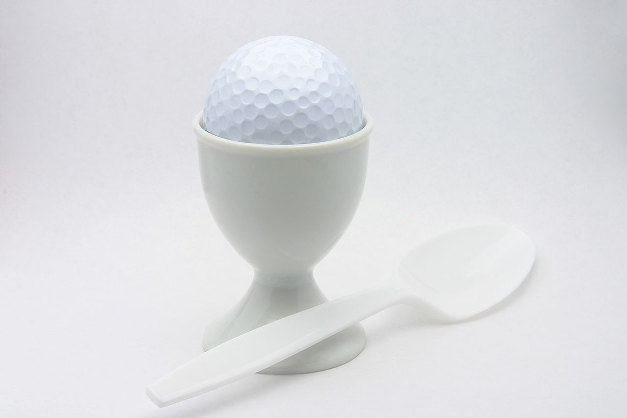 Breakfast ball image of a golf ball perched in an egg cup