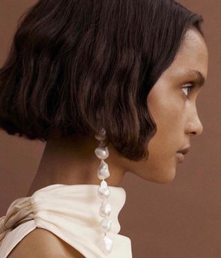woman wearing long pearl earrings