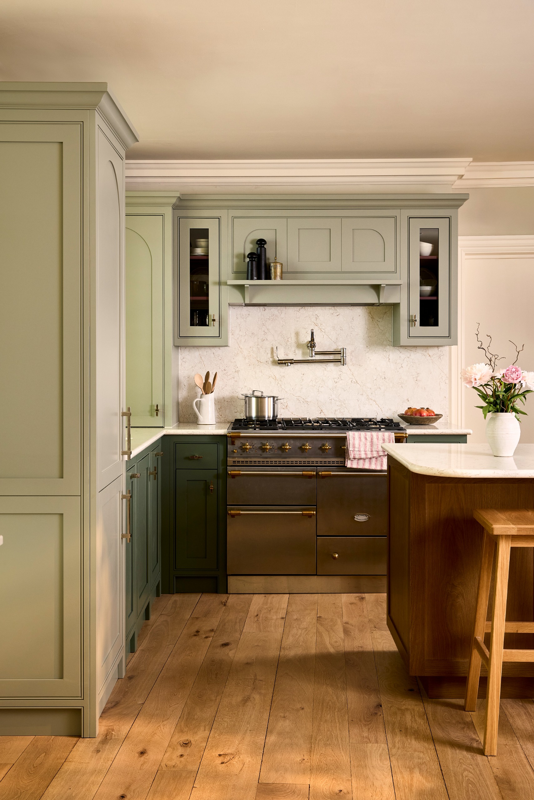 modern shaker kitchen with sage green cabinetry, a range cooker and a dark maroon island