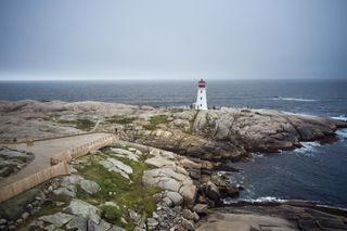 Landscape view of lighthouse, rocks and sea