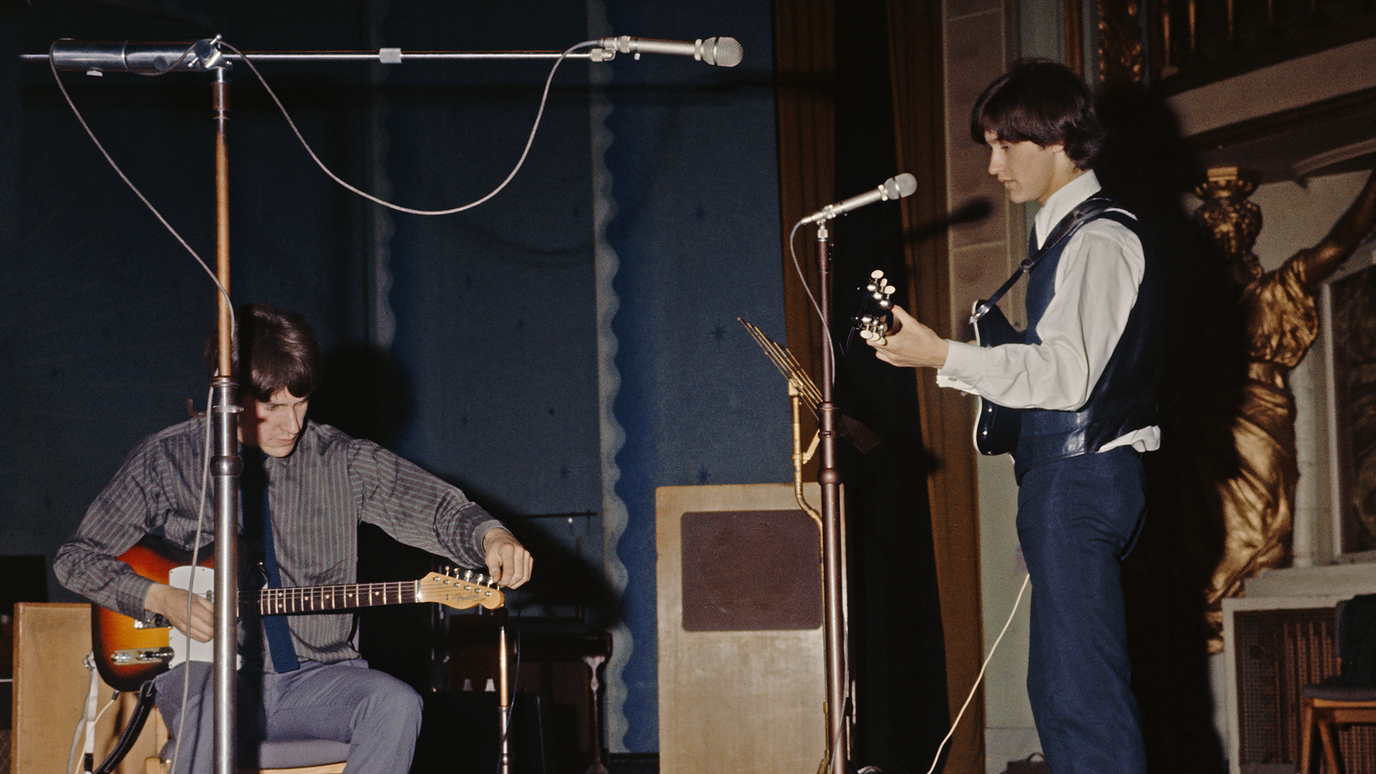 Ray Davies (left) and his brother Dave Davies, of The Kinks, at a soundcheck before a session for the BBC at the Playhouse Theatre, London, 7th September 1964.