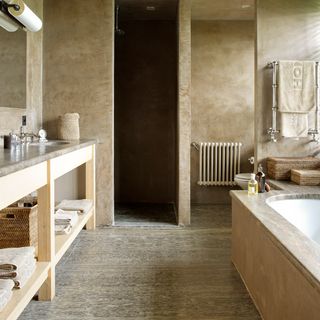 bathroom with limestone flooring and white bath tub
