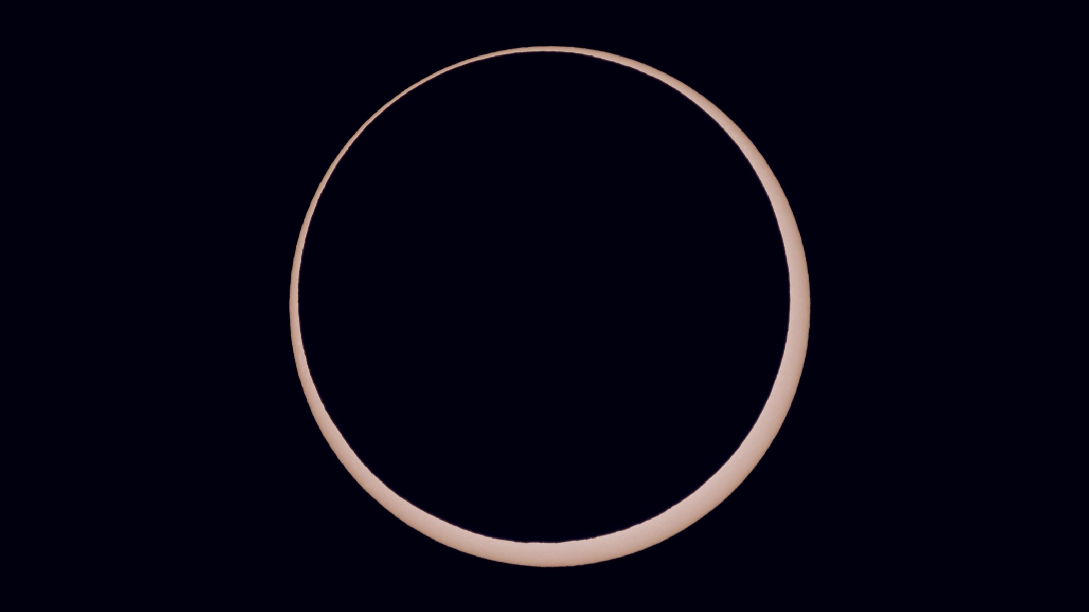 a ring of light around a black orb - this is an annular solar eclipse close up.