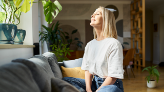 Woman sitting on sofa with eyes closed