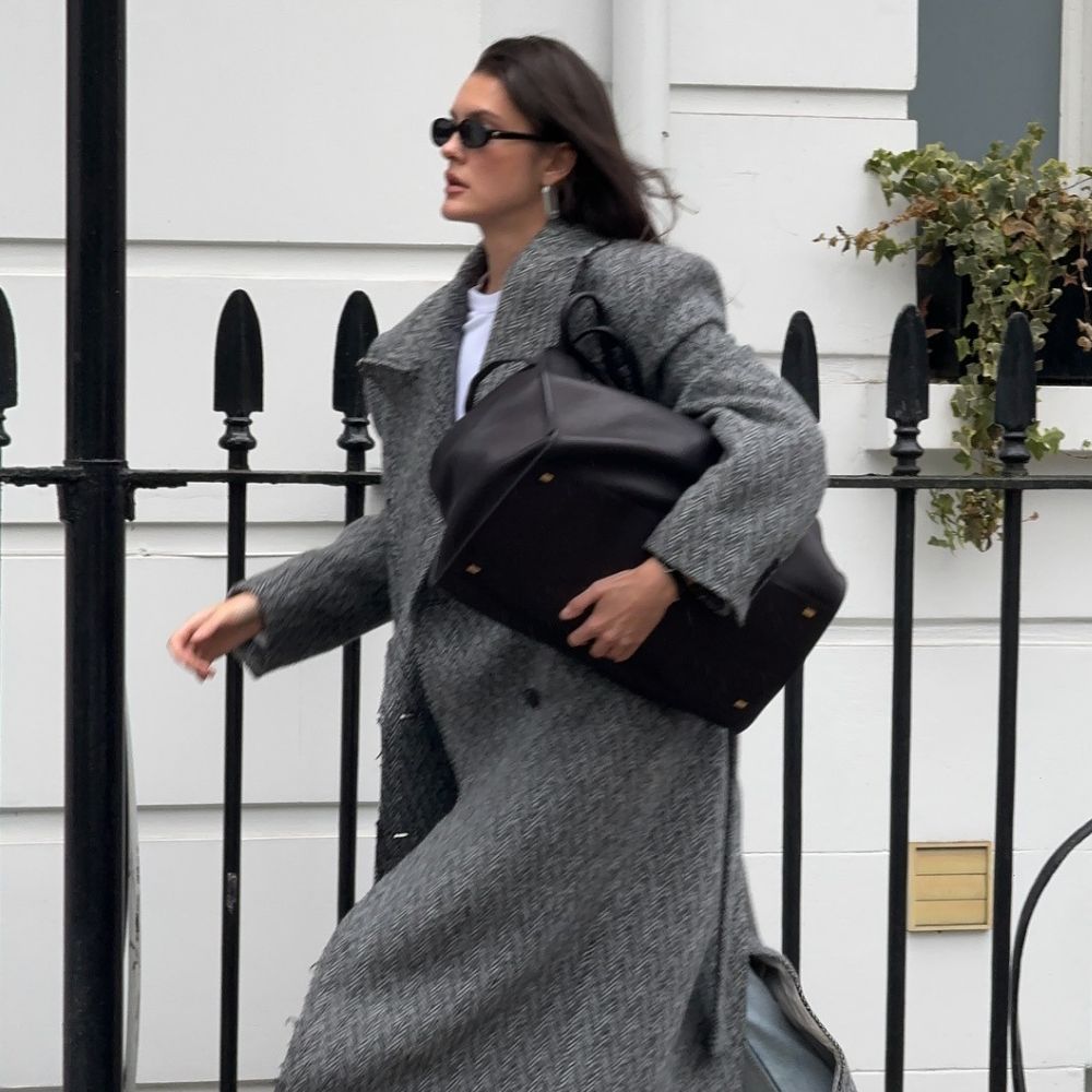 Influencer @sobalera wears a grey coat with blue jeans and black shoes.