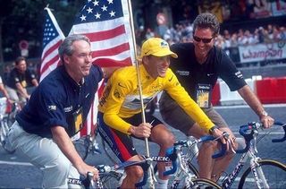 Thom Weisel rides alongside Lance Armstrong after his Tour de France victory