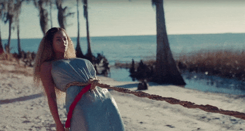 Beyonce on a beach with a rope around her waist