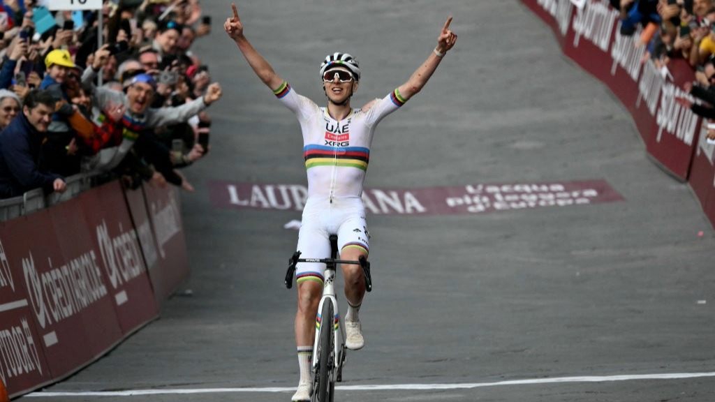 Tadej Pogacar raises his arms aloft after crossing the line to win the Strade Bianche 2025 road race