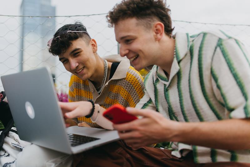 Two students sat watching something on a laptop