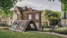 surrealist sculpture that resembles a bent brick house facade