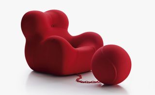Large red armchair with circular object attached by a chain