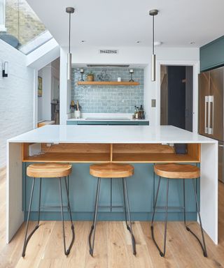 kitchen extension with white, blue and wood colour palette, glass section to side return and doors either side of the cooker leading to the rest of the house