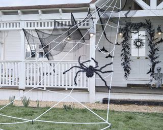front of home with spiderweb Halloween decorations