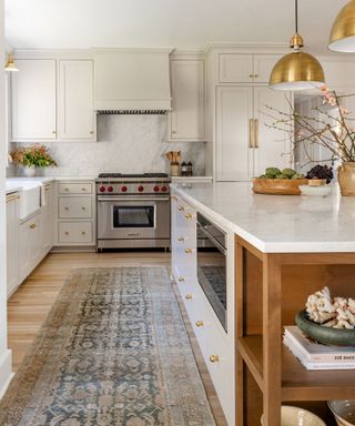 White kitchen with brass fittings and brass pendant lamps