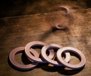 A stack of four cedar block rings on a wooden table.