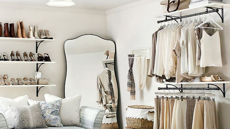 Bedroom with large mirror, valet shelving and shoes and valet shelving with rods to store clothes, shoes, bags and more