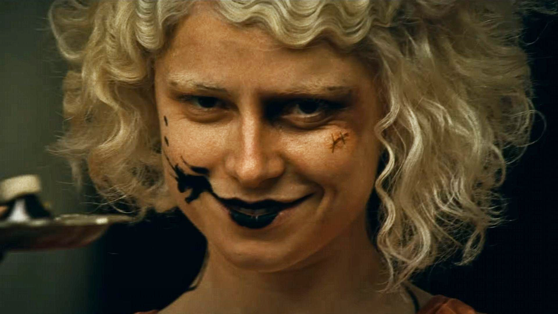 Jessie Buckley's The Bride smiling directly at the camera in 2026's The Bride! movie