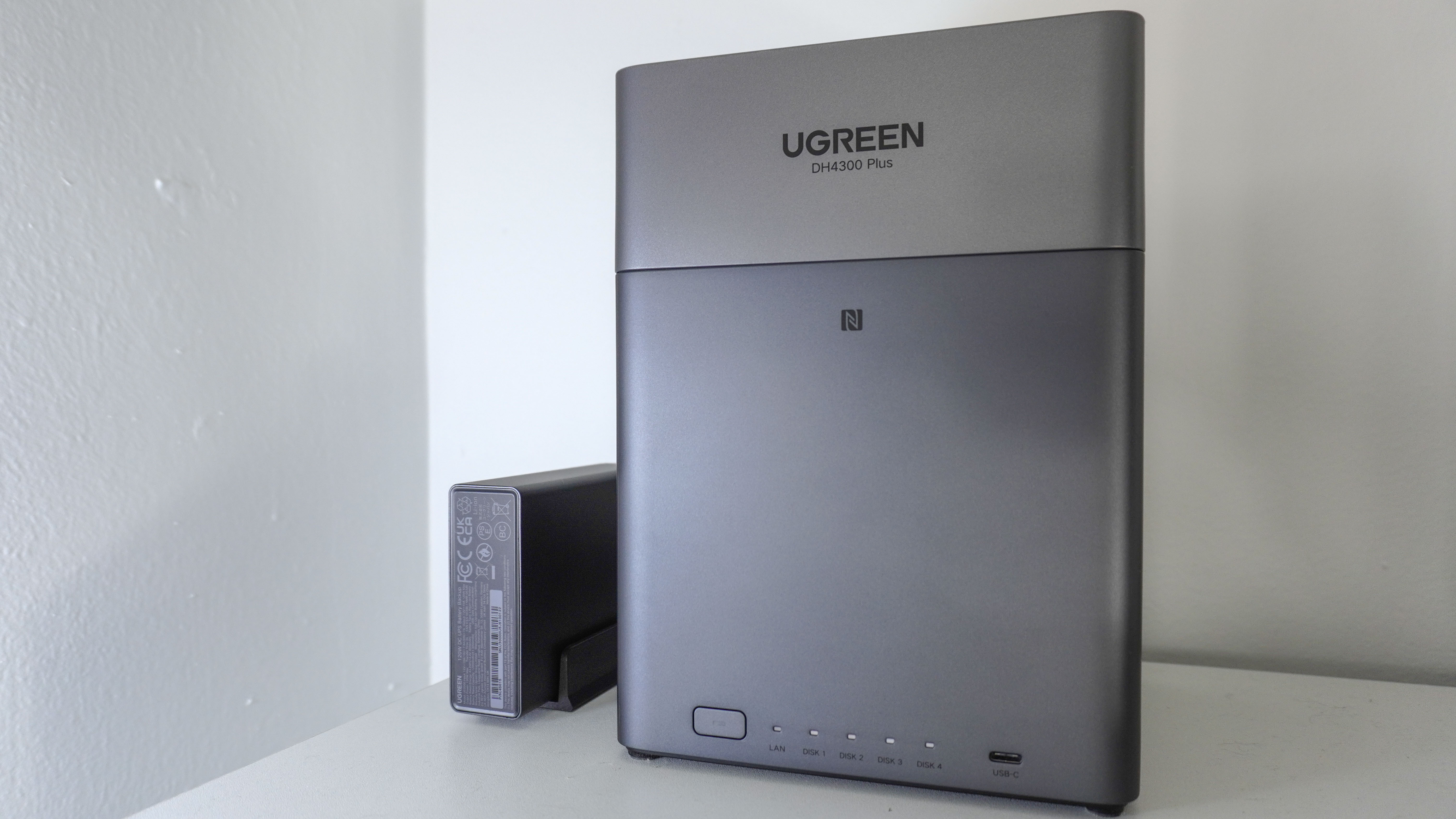 The Ugreen US3000 mini UPS next to a Ugreen NAS on a shelf