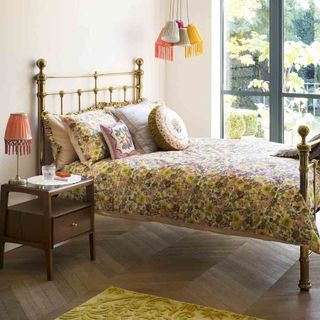 bedroom with floral bed and table lamp