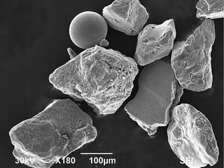 Geologists found angular, metallic fragments within sand from Omaha Beach, which they believe to be the remnants of shrapnel. They also found iron and glass beads, which they believe were created by the heat of mortar explosions. Above, a scanning electron microscope image of shrapnel grains and an iron bead.