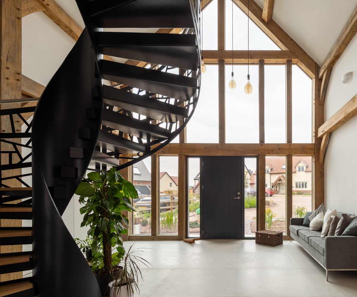 Front entrance with staircase to left side and sofa to the right side