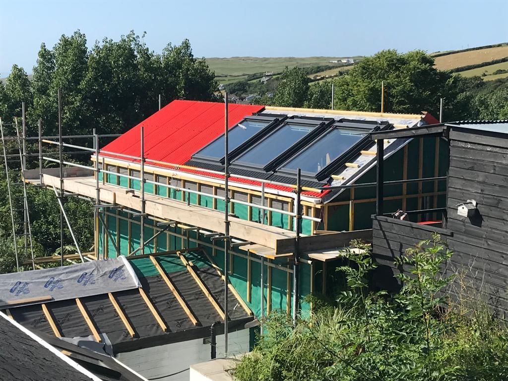 Roof and walls of a house being clad in Cladco plastisol coated corrugated steel sheets.