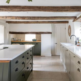 kitchen with cream cabinetry and green island and beamed ceiling