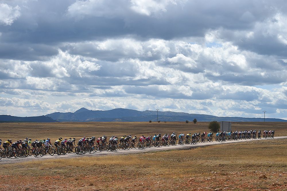 The peloton rides through a barren landscape during stage 18.