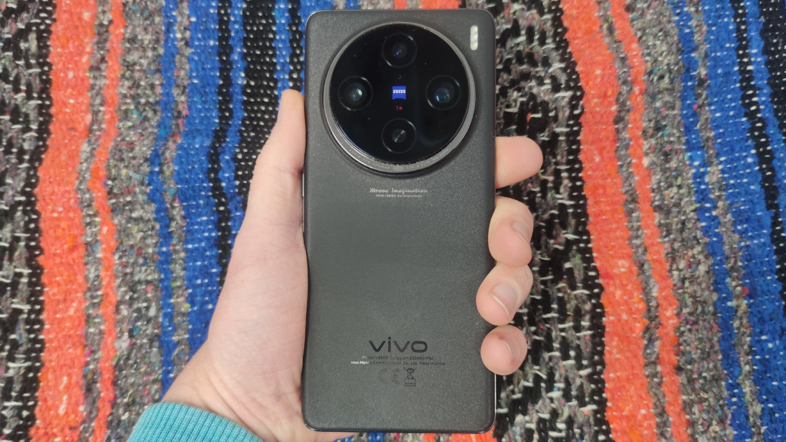 The Vivo X100 Pro on a colored background.