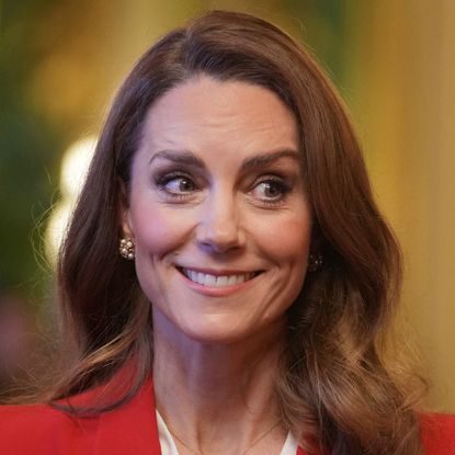 Princess Kate wearing a red dress and smirking